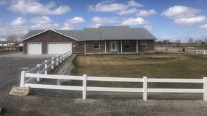 A two-story brick house with a garage, a front porch, and a fenced yard. - Country house in Montrose (Montrose)