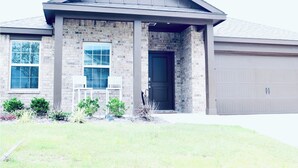 A two-story house with a brick facade, a dark front door, and a garage.