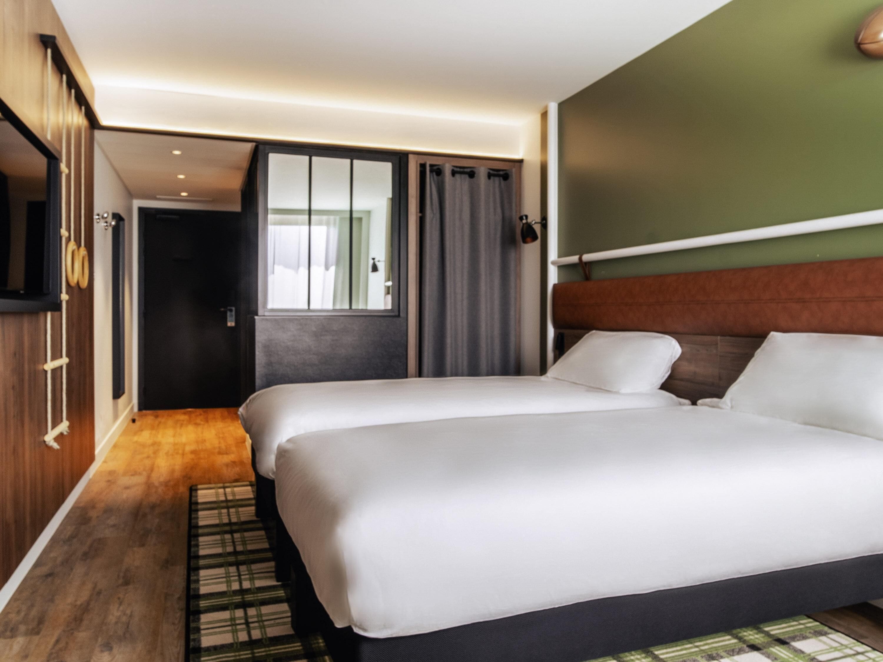 Une chambre d’hôtel avec un grand lit, une armoire, un miroir et un téléviseur.