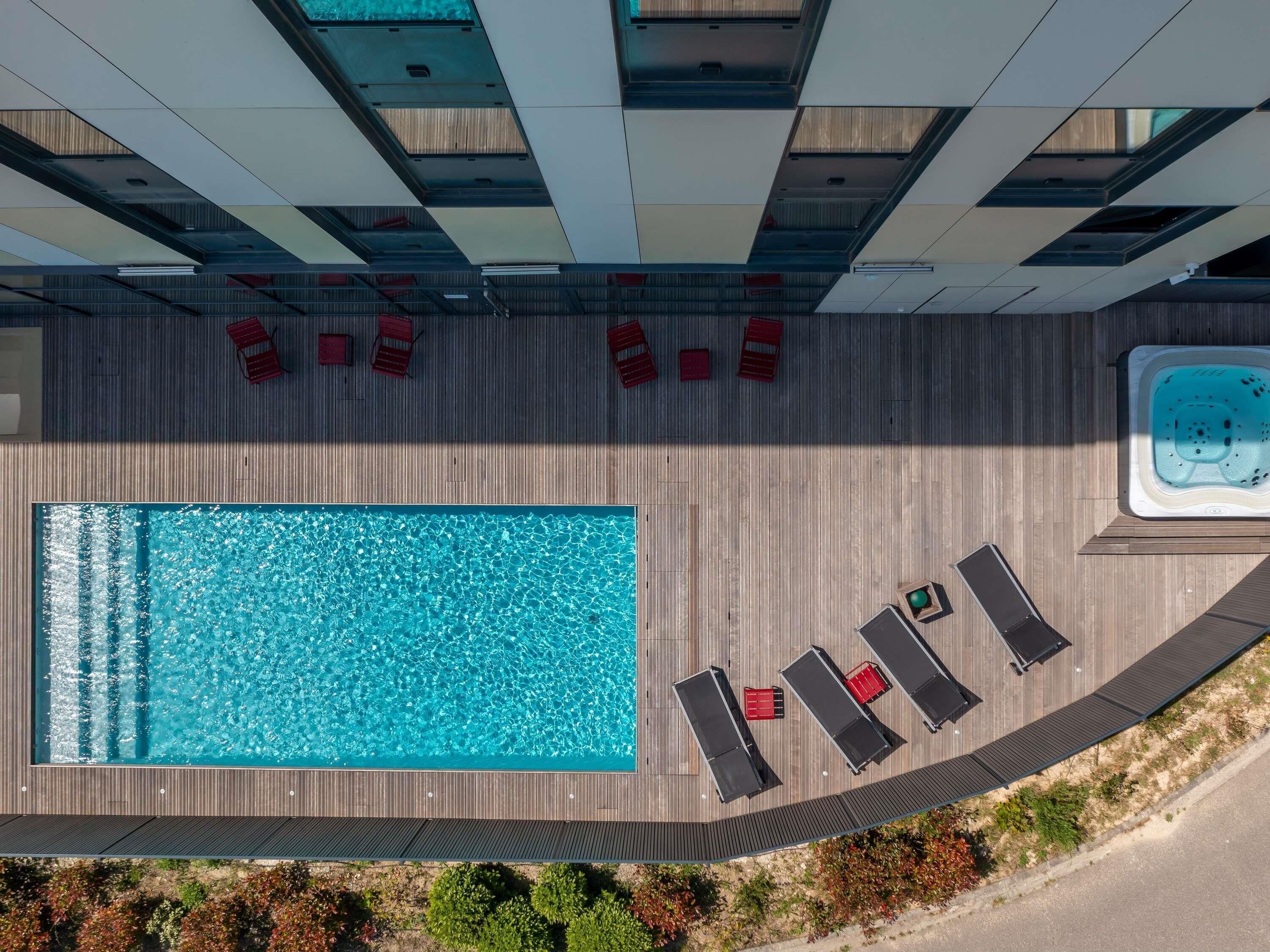 Una piscina al aire libre, sillones reclinables de piscina