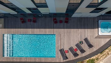 Una piscina al aire libre, sillones reclinables de piscina