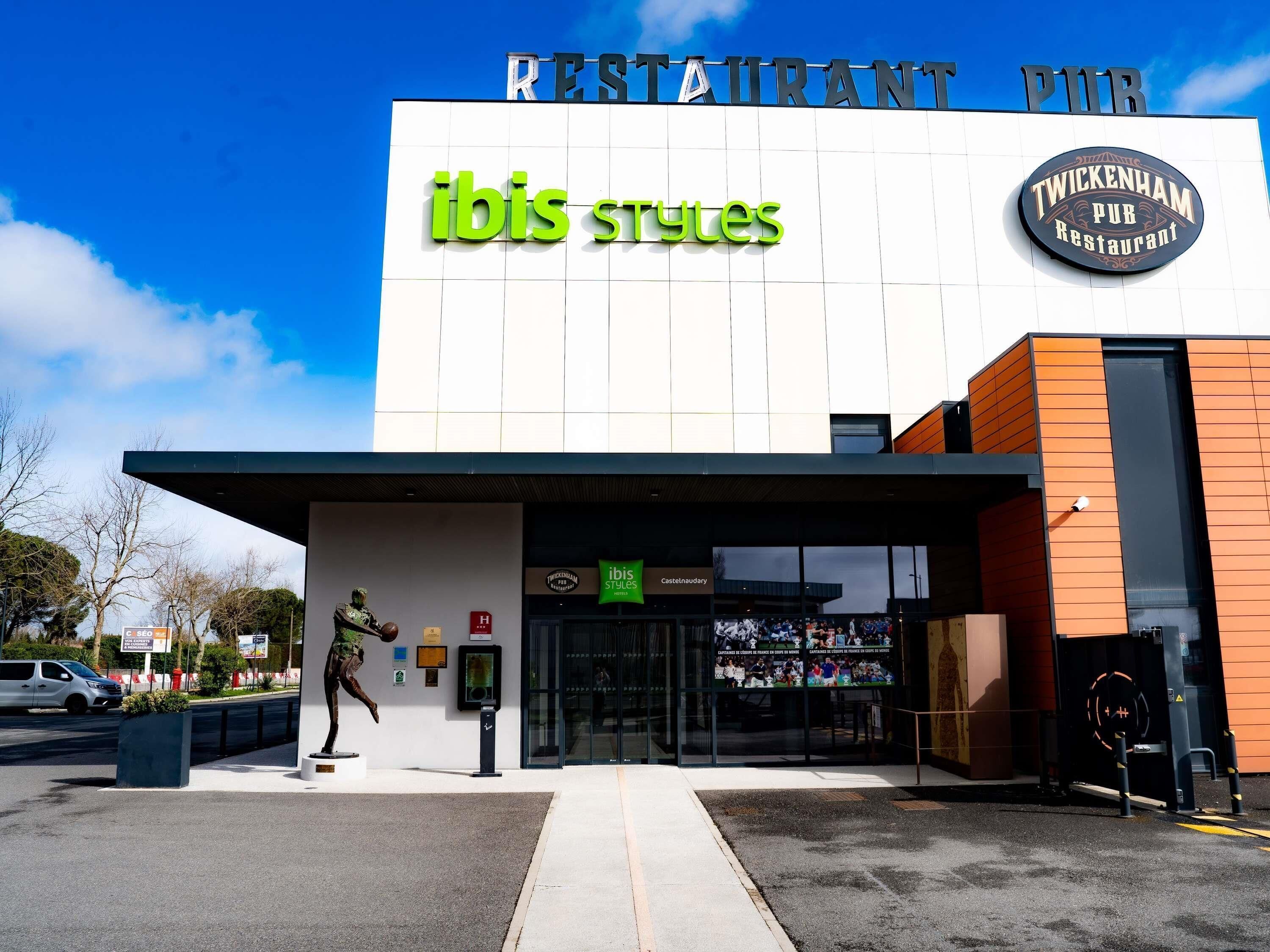 A modern building with a sign for 'ibis styles' and 'TWICKENHAM PUB Restaurant' on the facade.