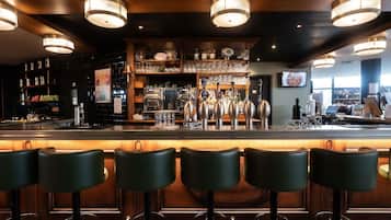 Een bar met verschillende krukken, een bar en een koffieapparaat.