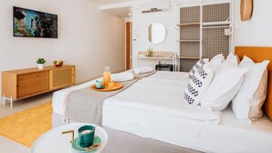 Una habitación de hotel moderna con una cama, mesita de noche y una pequeña zona de estar.