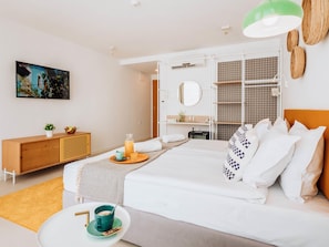 A modern hotel room with a bed, bedside table, and a small seating area.