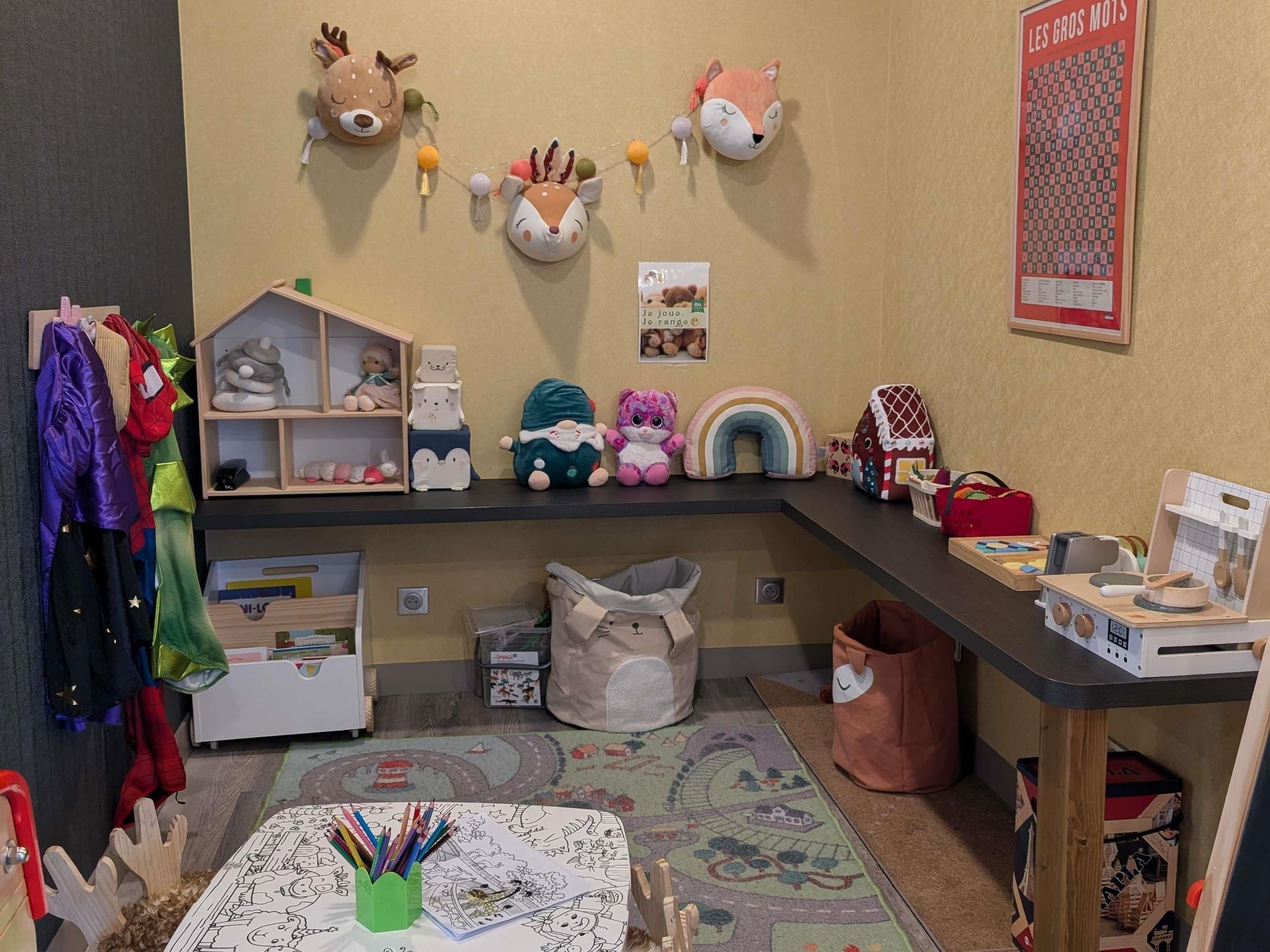 Een kinderspeelruimte met een plank, speelgoed, een vloerkleed en een wanddecoratie.