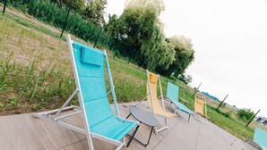 Outdoor lounge chairs on a patio with a pool. - ibis Styles Contres Cheverny (Le Controis en Sologne)