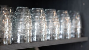A shelf with green and clear glass items. - ibis Styles Contres Cheverny (Le Controis en Sologne)