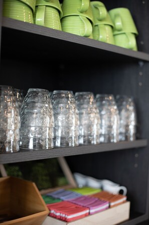 Une étagère avec des objets en verre vert et transparent.