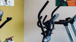 A gym with stationary bikes and ellipticals, wooden flooring, and artwork on the walls. - ibis Styles Contres Cheverny (Le Controis en Sologne)