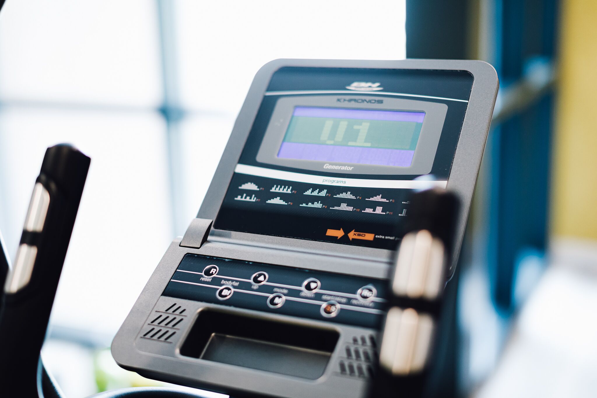 A treadmill with a digital display, control buttons, and a small screen.