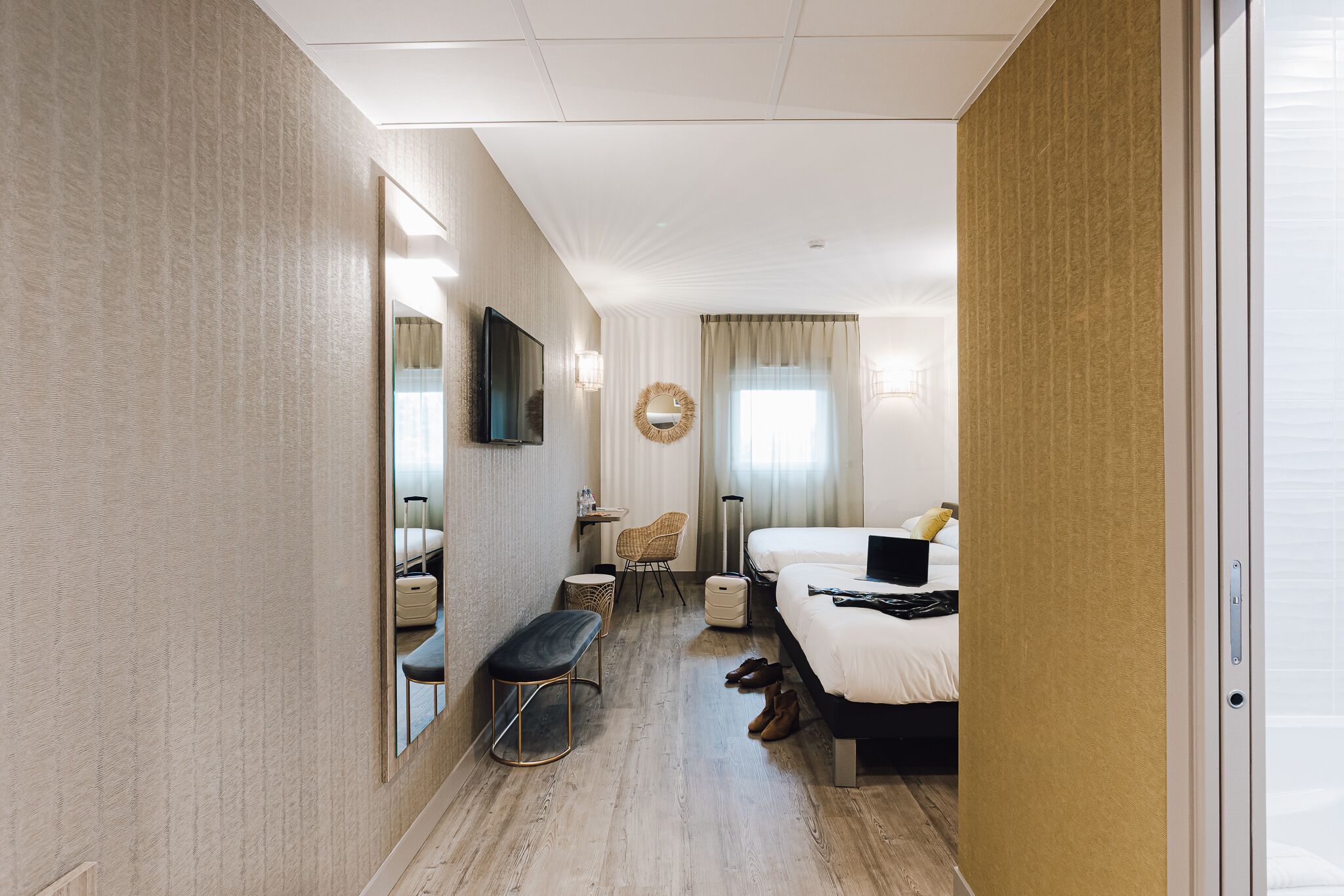 Ett hotellrum med en stor säng, ett skrivbord, en stol, en tv och en spegel.
