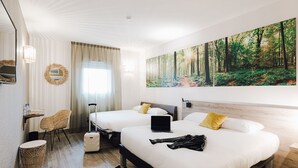A hotel room with two beds, a desk, a chair, a suitcase, and a large forest-themed painting on the wall. - ibis Styles Contres Cheverny (Le Controis en Sologne)