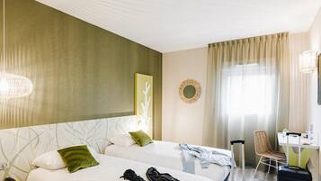 Een hotelkamer met twee bedden, een bureau, een stoel en een koffer.
