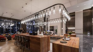 Zona de bar moderna amb un taulell corbat, diverses opcions de seients i llums penjants.