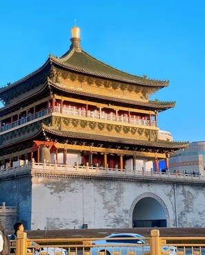 A traditional multi-tiered building with a prominent central tower and a large arched entrance.