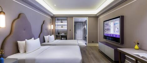 A modern hotel room with two beds, a flat-screen TV, a desk, and a minibar.