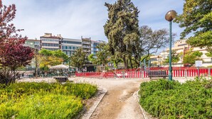 A paved pathway leading to a building with a red and white fence. - GuestReady - Tower- 3 Bedroom Apt in Saldanha (Lisboa)