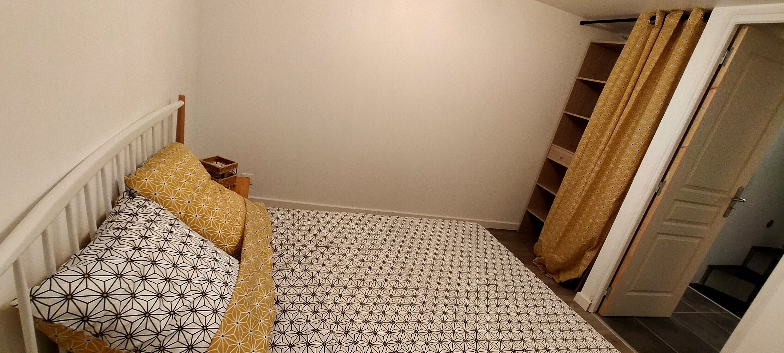 A bedroom with a bed, a nightstand, and a wardrobe.