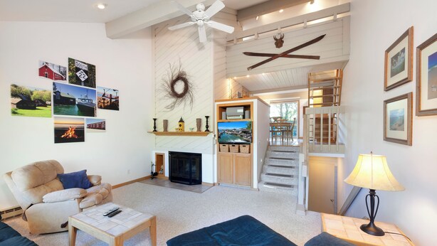 A spacious living room with a fireplace, a television, and a staircase leading to an upper level. - 3 bed 3 bath, Well maintained, Outside heated pool (Cedar)