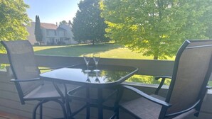 A deck with a glass-top table and two chairs. - 3 bed 3 bath, Well maintained, Outside heated pool (Cedar)