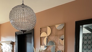 Un couloir agrémenté d’un mur recouvert de miroirs décoratifs, d’une armoire en bois et d’un sol à motifs.