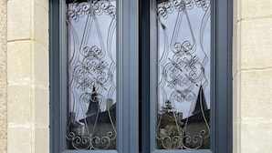 Une paire de portes bleu foncé, ornées de motifs métalliques et dotées de poignées en laiton.