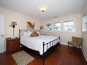 A bedroom with a bed, bedside tables, a chair, a window, and artwork on the wall. - Across from The Barlow/Wine country (Sebastopol)