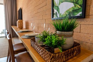A dining area with a wooden table, a woven tray with plants, and a framed artwork on the wall. - Tabas | Lux Apto Itaim | Design Moderno I002 (SP)