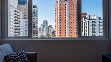 A room with a large window overlooking a cityscape with various buildings.