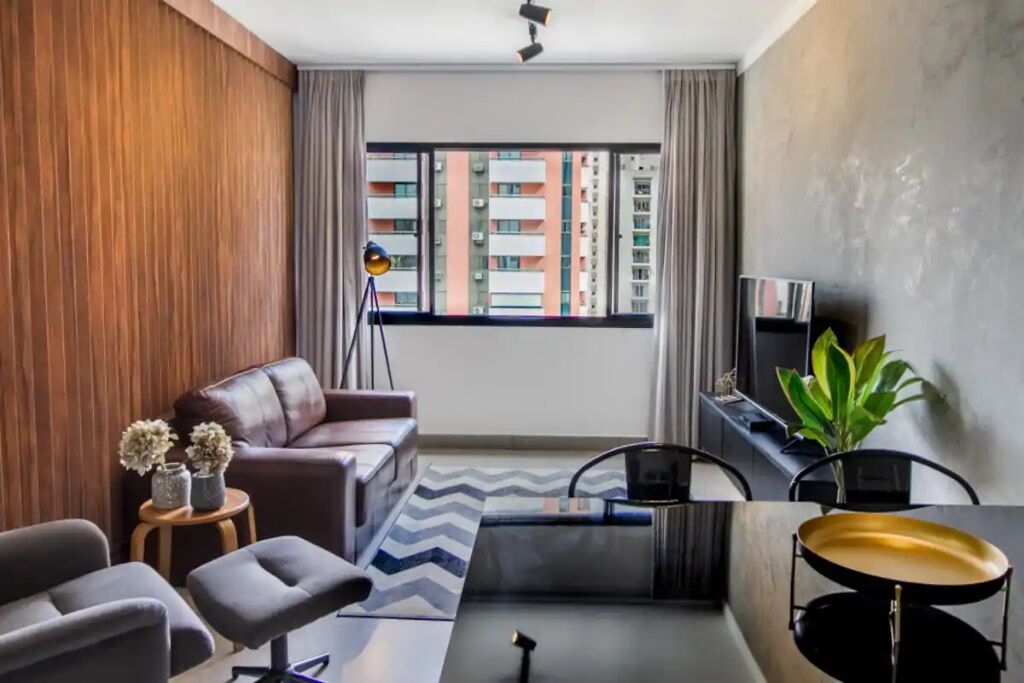 A modern living room with a sofa, chairs, a coffee table, a floor lamp, and a television.
