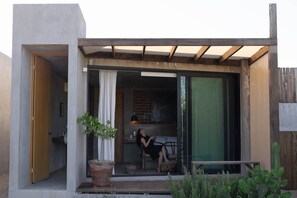 Ein modernes Haus mit einer Terrasse, einer Schiebetür und einem Holzboden.
