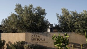 A sign for "CASA MICHAUS" with a desert garden featuring cacti and shrubs.