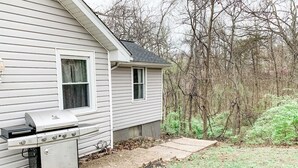 A house with a barbecue grill in the backyard.