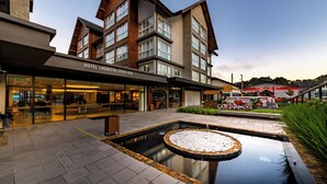 A hotel with a modern design, featuring a courtyard with a circular water feature and a pool. - Laghetto Stilo Vita (Gramado)