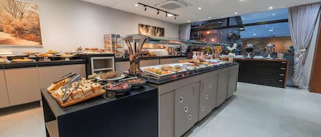 Una cocina moderna de hotel con un bufé, que presenta diferentes tipos de alimentos y una estación de café.