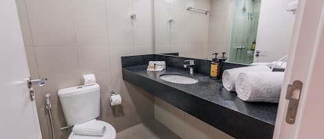 A modern bathroom with a toilet, sink, and shower.