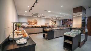 A modern breakfast buffet with various food items and a clean, well-lit interior. - Laghetto Stilo Vita (Gramado)