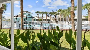A pool area with palm trees and a covered walkway.
