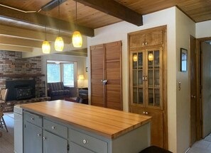 Enjoy cooking and socializing in this spacious kitchen with a central island, brick fireplace, and comfortable seating area.