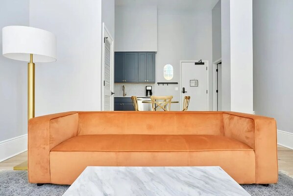 A modern living room with a sofa, a coffee table, and a lamp.