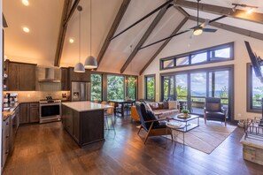 A spacious kitchen with modern appliances, a dining area with a view, and a cozy seating area. - Lucky Landing - BRMC amenities, pets, views, hot tub, fire pit, game tables (Boone)