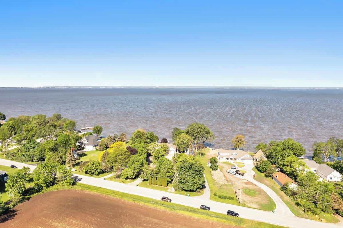 An aerial view of a residential area with houses, roads, and a body of water.