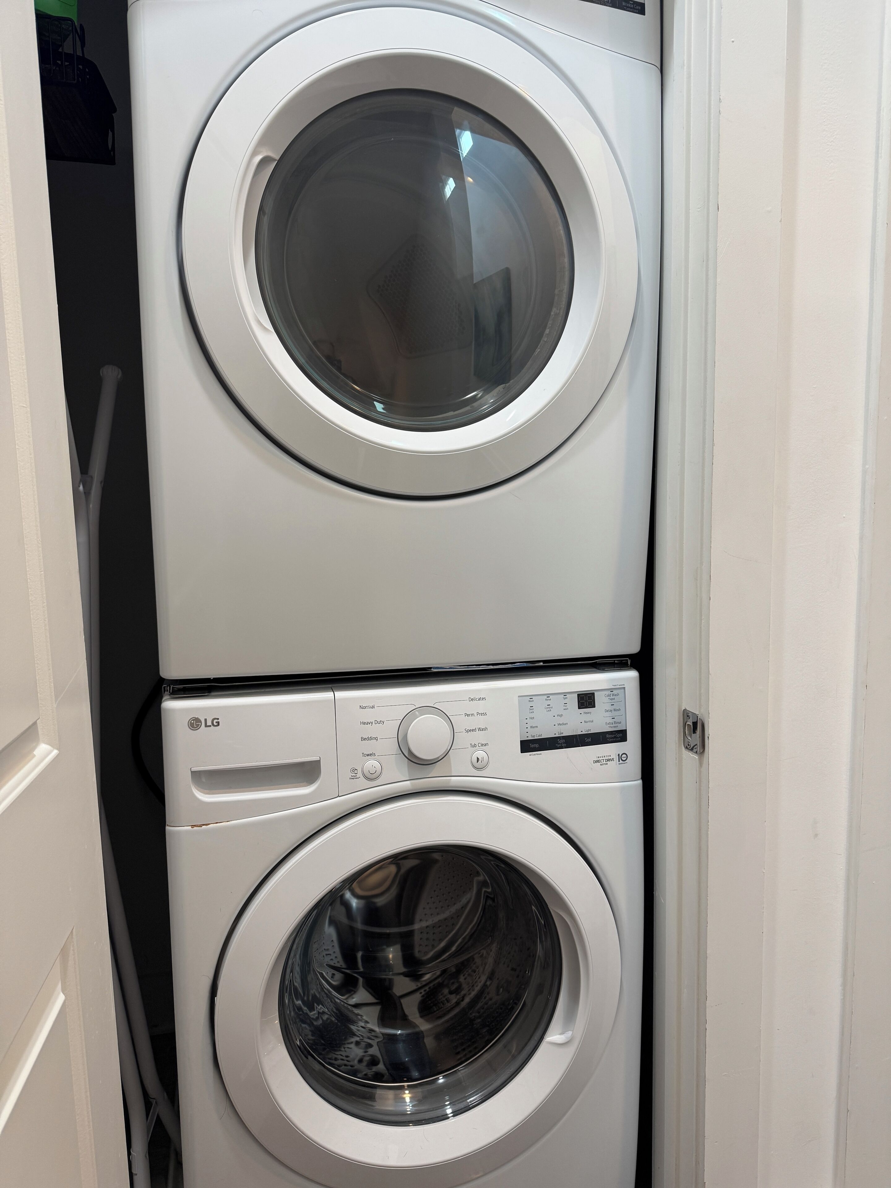 A stacked washer and dryer unit with control panel and buttons.