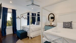A room with a four-poster bed, a bedside table with a lamp, a mirror, and a window with curtains. - Luxury Townhouse with rooftop view of downtown! (Nashville)