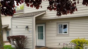 A two-story residential building with a front door, a small porch, and a mailbox. - 2 King Master Suites, Outside heated pool, Close to Dunes (Cedar)