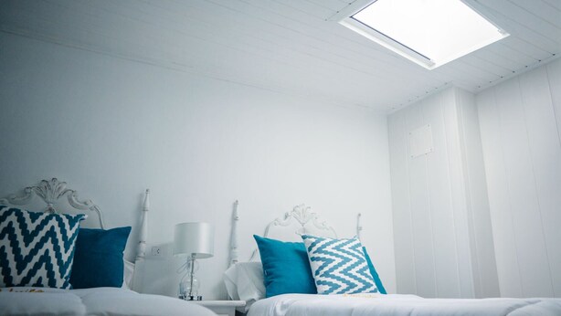 A room with two beds, a nightstand, a lamp, and a ceiling light. - Casa a Boleriña 1 (Poio)
