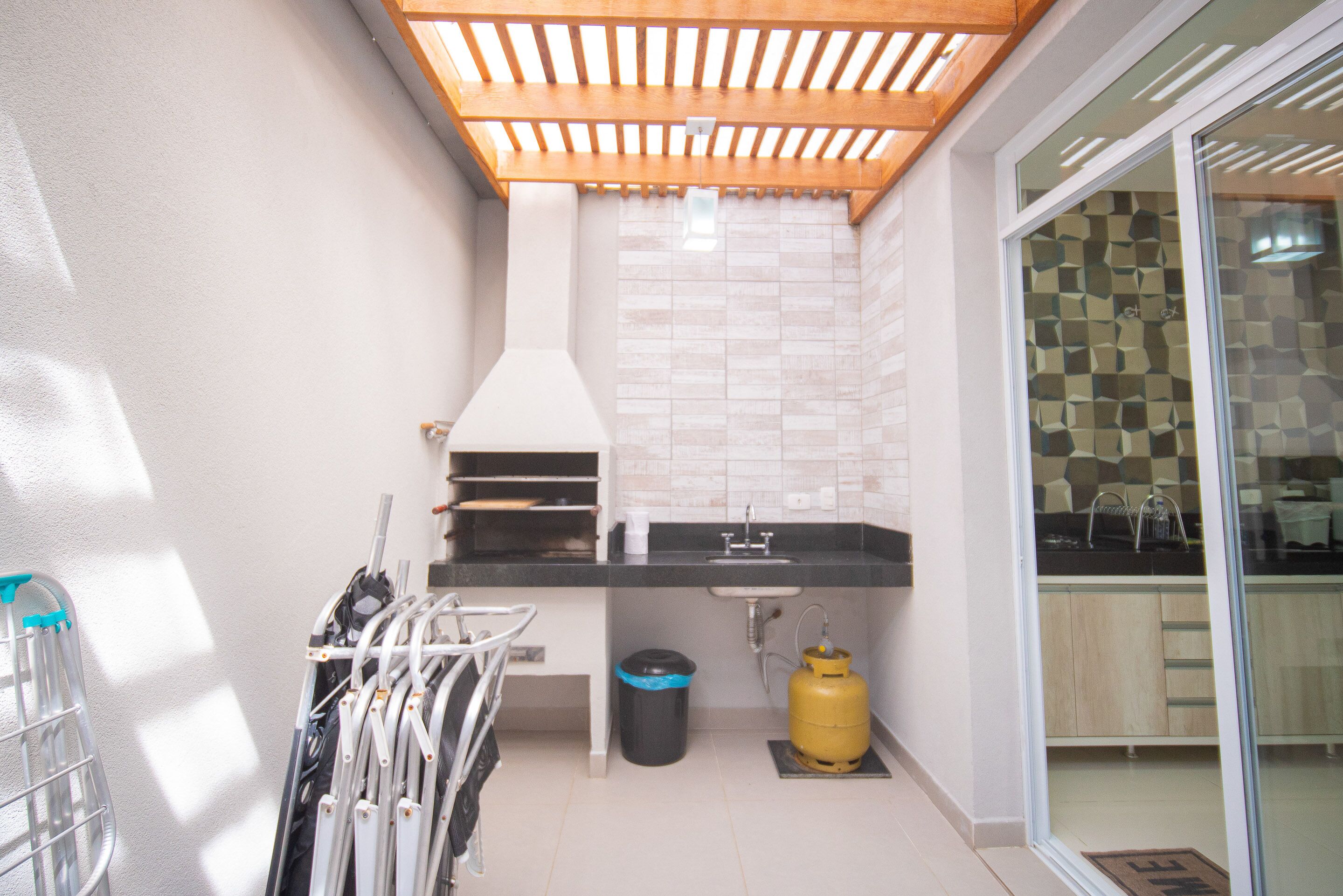 Uma cozinha compacta com forno embutido, pia e fogão a gás.