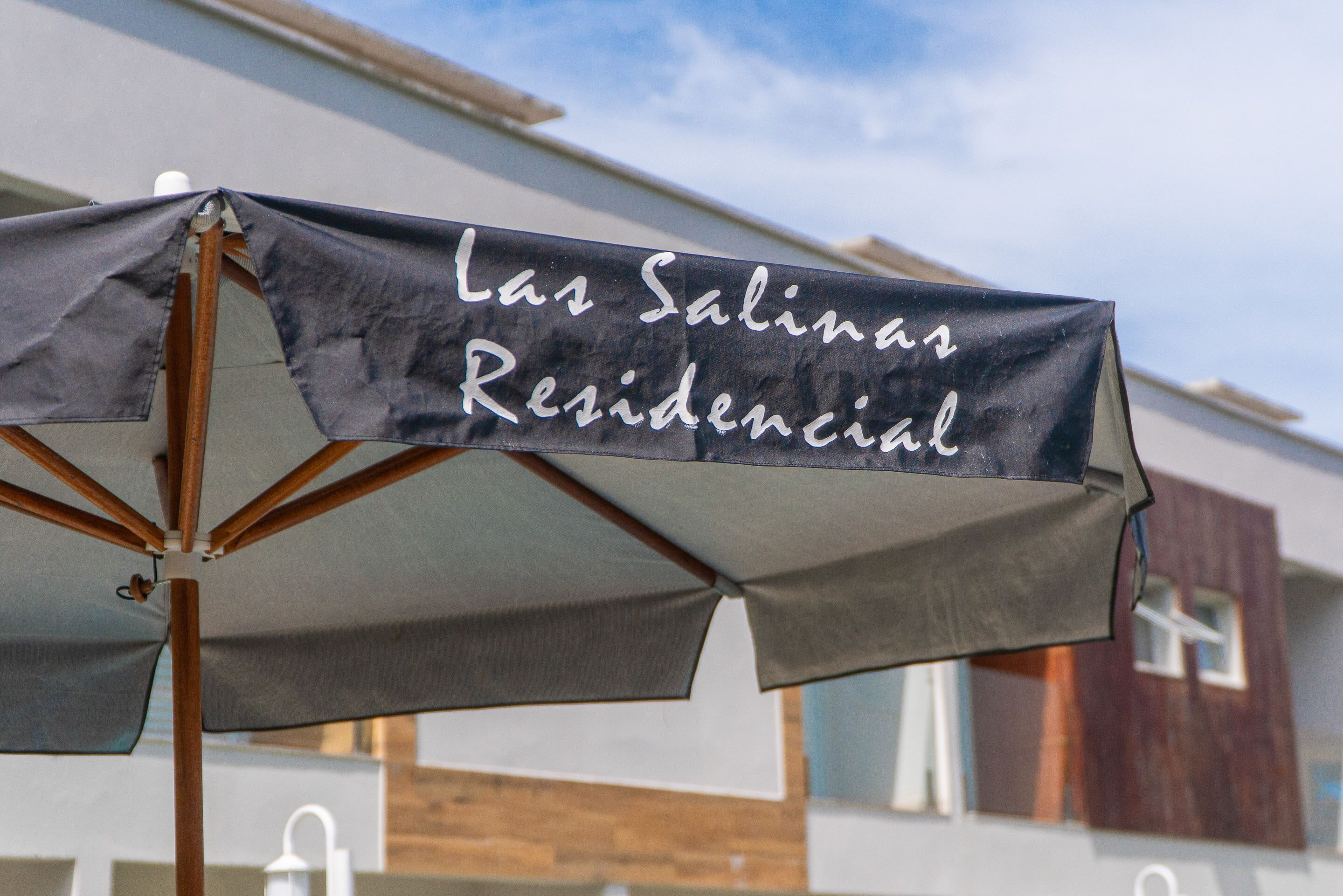 A sign with the text "Las Salinas Residencial" on an umbrella structure.
