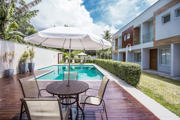 Una piscina al aire libre, sombrillas